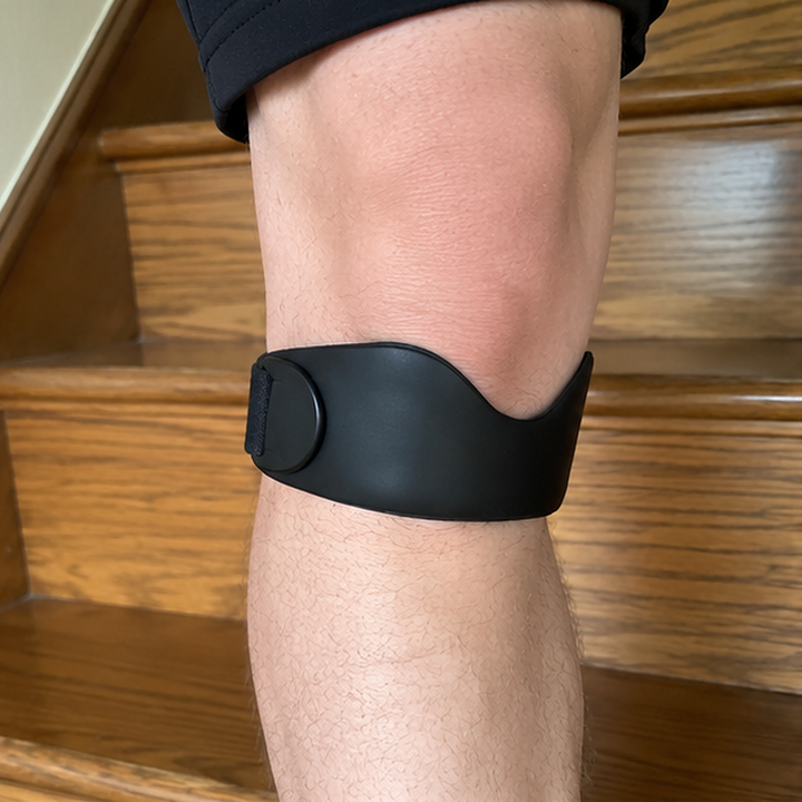 Ein Knie mit dem Kneova-Band auf einem Treppenabsatz